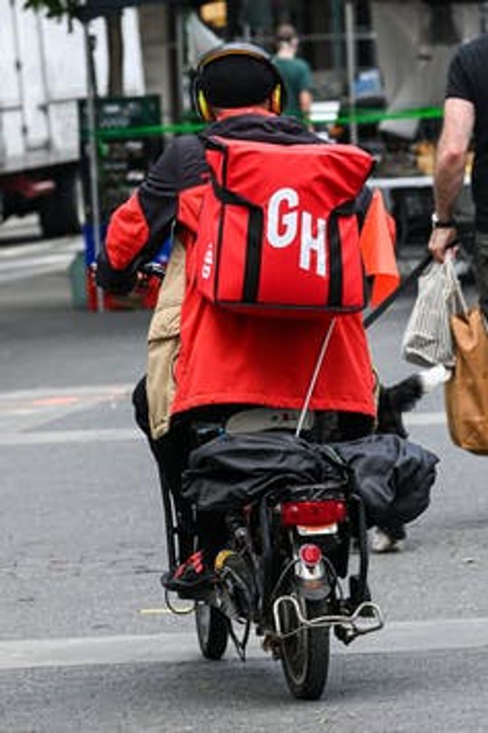 A Grubhub delivery man speeds off on his electric bike to make a delivery on May 29 in New York City.