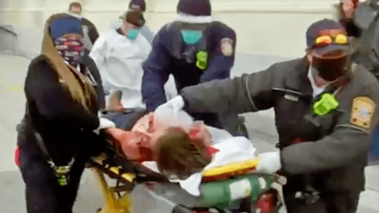 WATCH: Paramedics bring bloody woman out of capitol on a stretcher