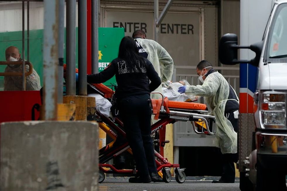 Healthcare workers wheel a patient into a New York hospital on a gurney.