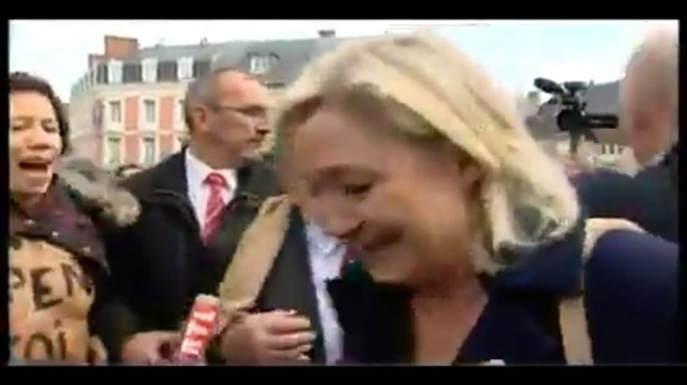 Far-right French politician Marine Le Pen confronted by topless Femen protesters