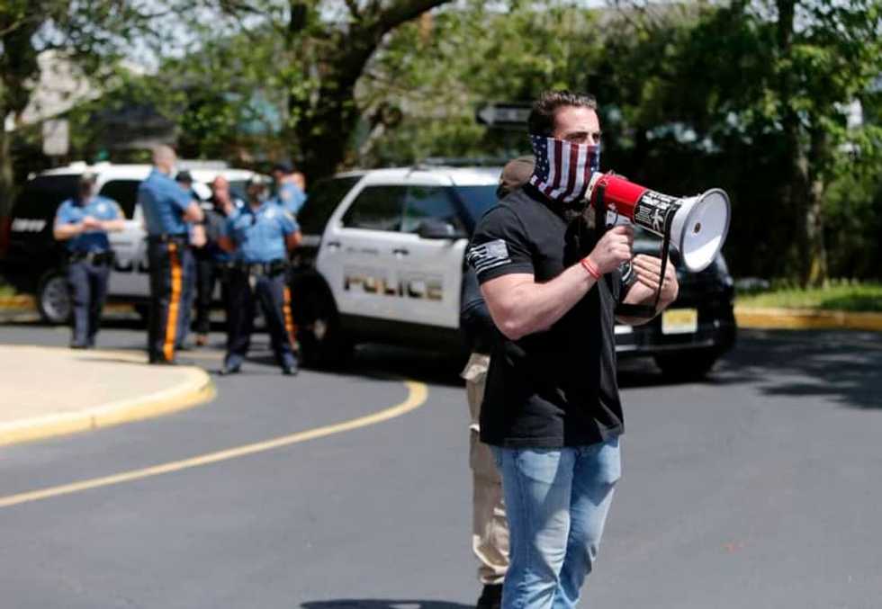 White supremacist sticker spotted on megaphone used by gym owner defying coronavirus restrictions