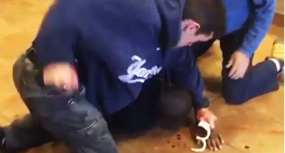 NYPD cop caught on video punching and kneeing black suspect in the head while he's held down