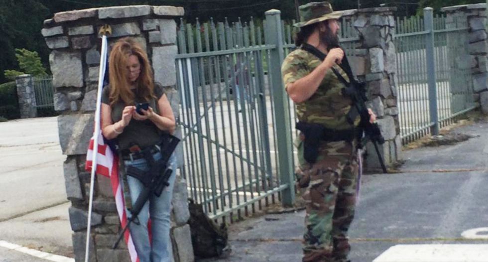 Armed militia members stand by as Confederate flag supporters descend upon Georgia park