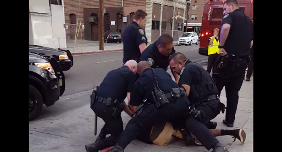 'He's a f*cking kid': Video shows nine California cops arrest sobbing black teen 'for jaywalking'