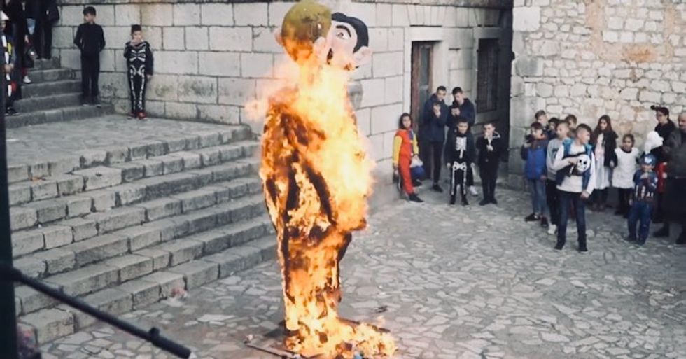 Carnival celebration includes burning effigy of kissing same-sex couple as children watch and adults applaud