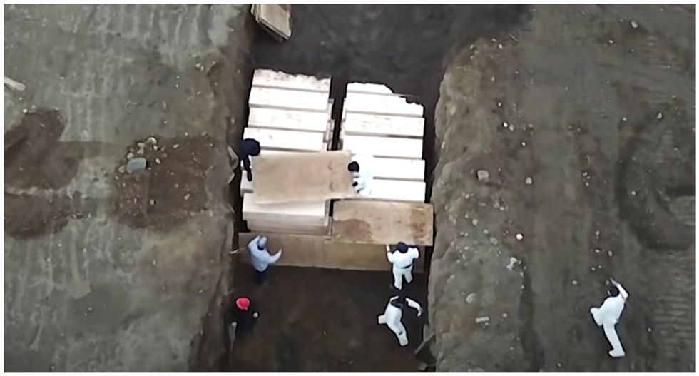 Drone footage shows caskets of coronavirus victims being loaded into mass grave