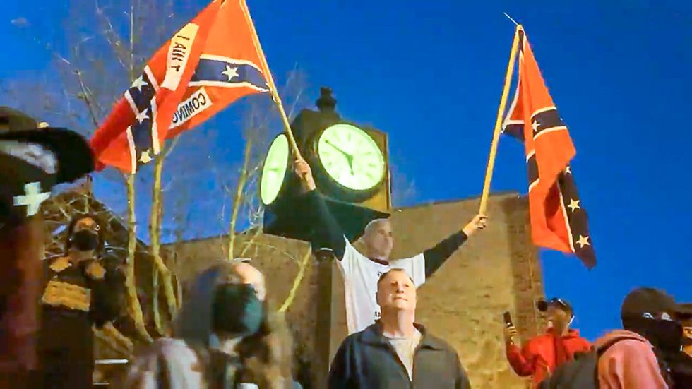 Group with Confederate flags confronts liberal voters as they march to the polls in North Carolina