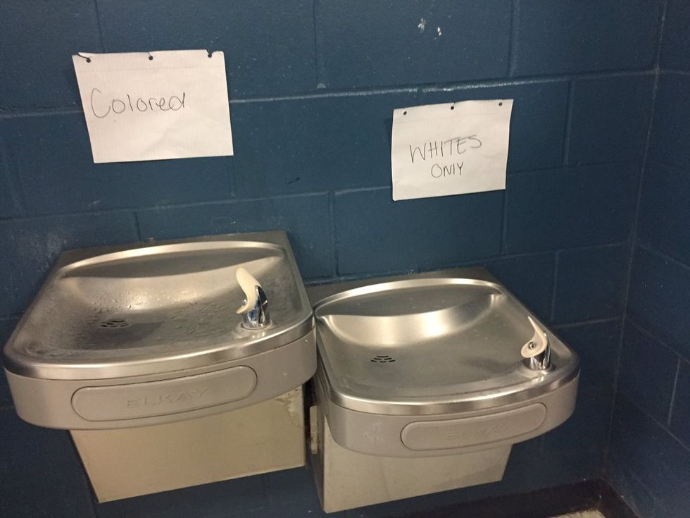 Vandals post 'whites only' and 'colored' signs above water fountains in Florida school