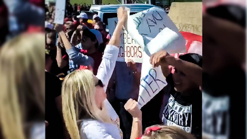 WATCH: Trump supporter rips up Latino protester's sign at Iowa tailgate event