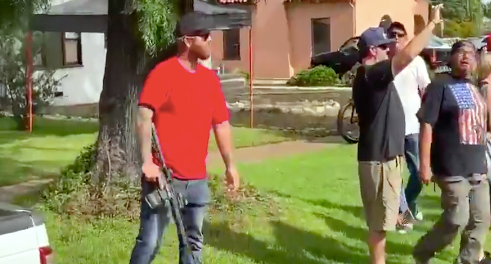 WATCH: Man jumps out of pickup to point rifle at protesters confronting Trump supporters