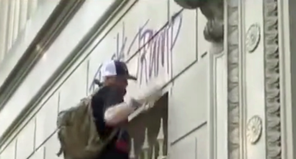 WATCH: Protester scales Secret Service building to spray-paint profane anti-Trump message