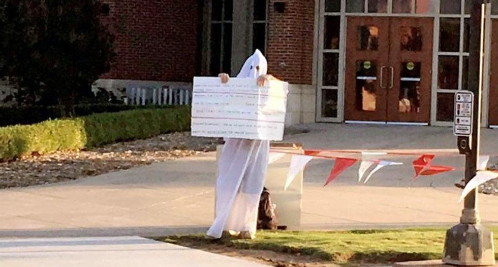 ‘Not part of KKK’: Man in white hood and robe insists he is just warning students about evolution
