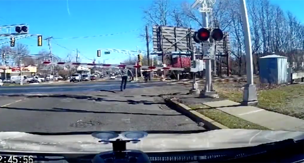 WATCH: Driver leaps from car to save elderly woman from oncoming train