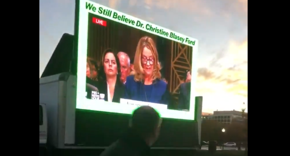 Protestors set up giant broadcast of Christine Blasey Ford's testimony as conservative lawyers gather to celebrate Kavanaugh