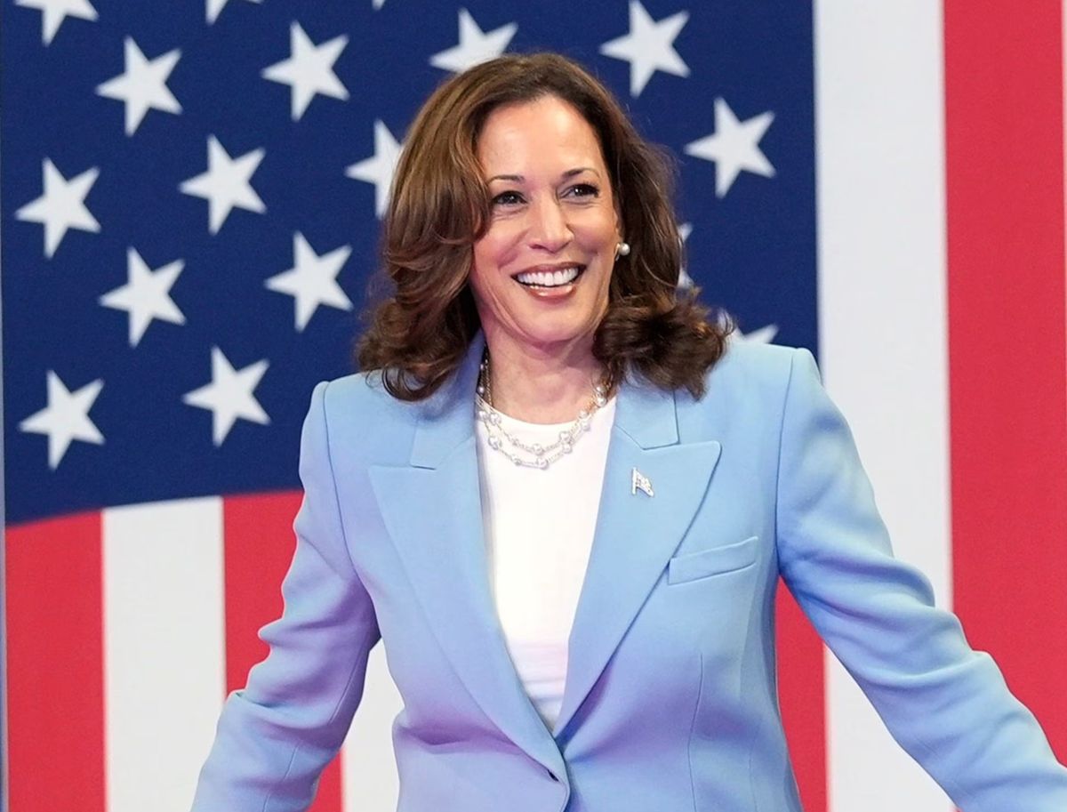 Kamala Harris walks in front of a flag
