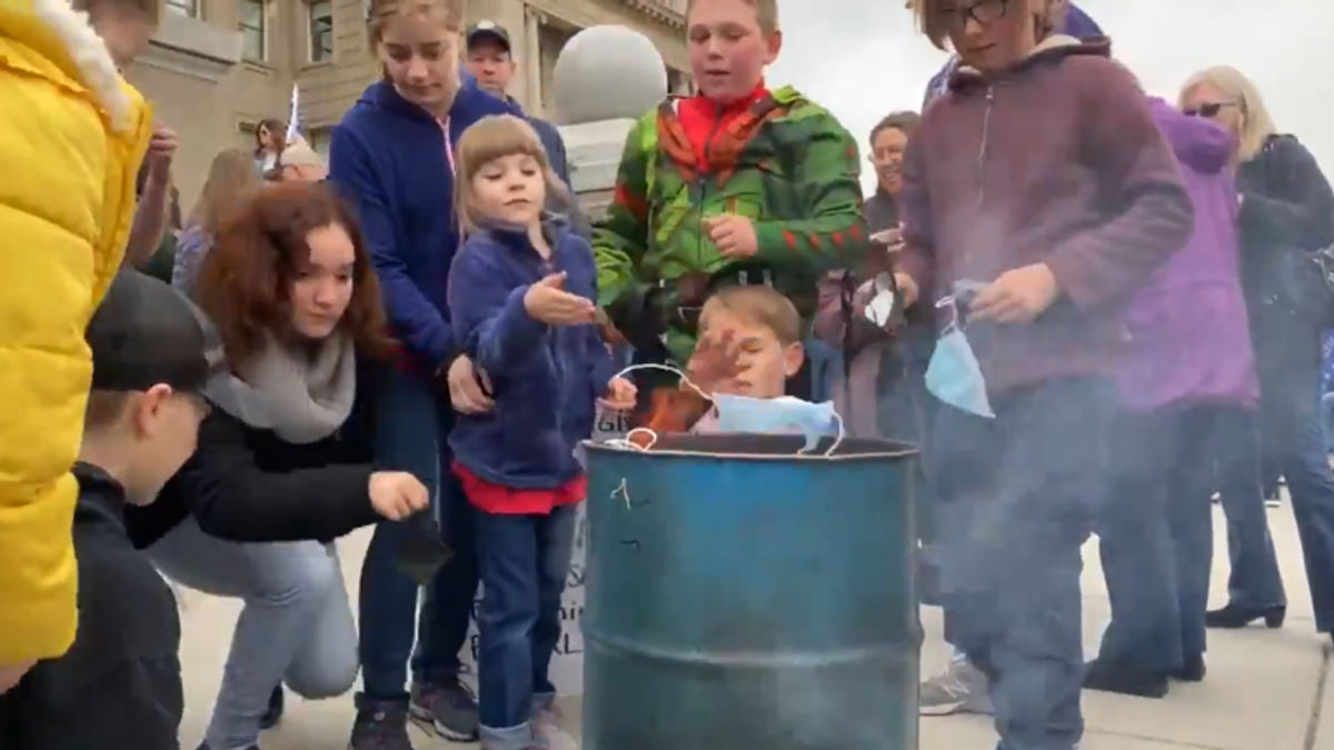 WATCH: Idaho COVID deniers encourage kids to burn their masks on state capitol steps