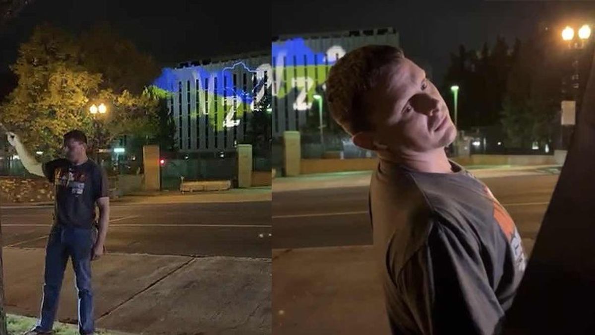 Pro-Ukraine protesters humiliate Russian Embassy staffer who waved umbrellas to block projections